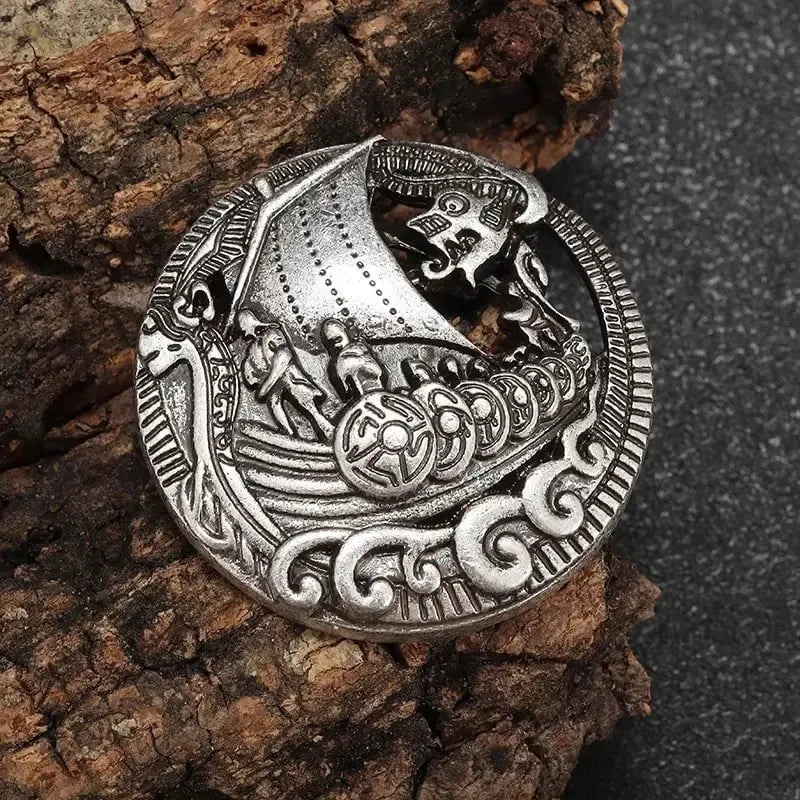 Silver Viking ship brooch with Norse longboat voyage design, intricate details, and dragon prow.