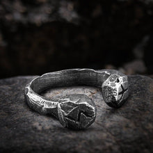 Viking stainless steel rune cuff ring with dark, textured finish on a stone.