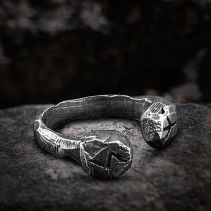 Viking stainless steel rune cuff ring with dark, textured finish on a stone.