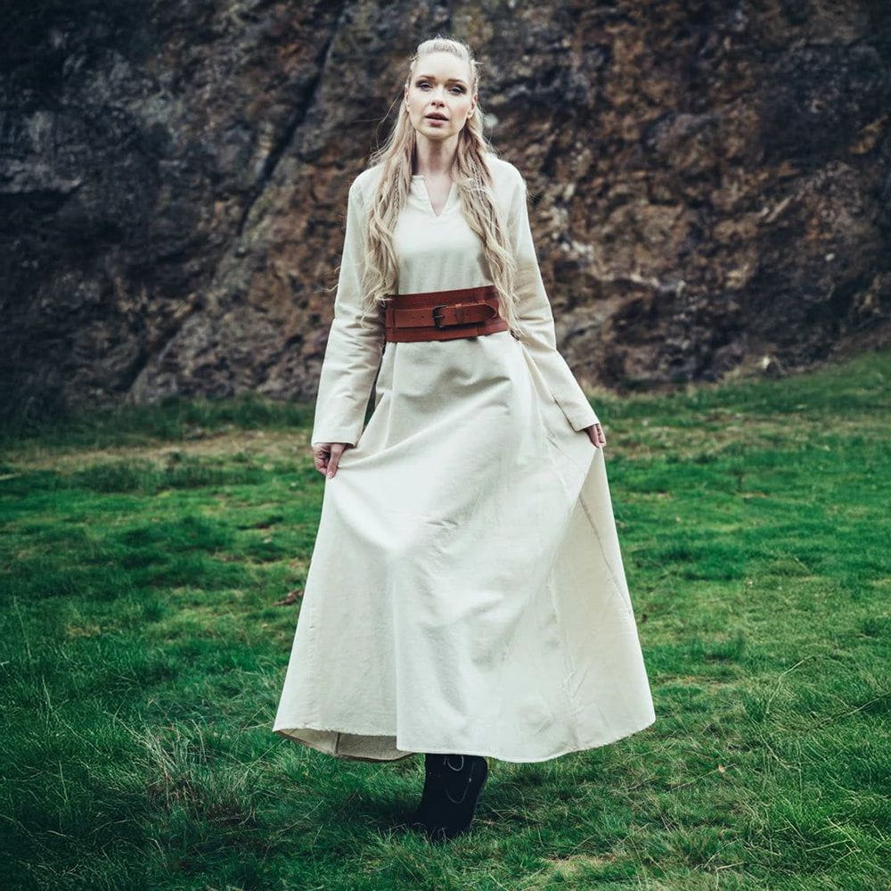 Viking woman in a long, natural white cotton underdress with a brown leather belt.