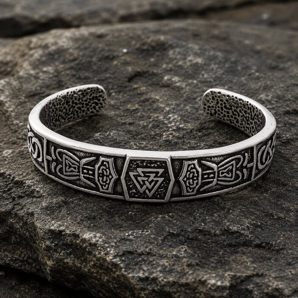 Viking Valknut cuff bracelet in silver, featuring shield and knotwork panels on a dark rock.