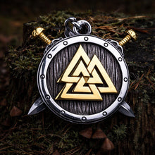 Viking Valknut shield pendant: silver and gold, with crossed swords, on a mossy tree stump.