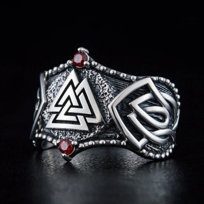 Viking Valknut silver ring with red stones, intricate knotwork, and textured details.