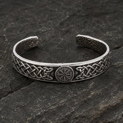 Viking silver cuff bracelet with Vegvisir symbol and Celtic knotwork on a dark stone.