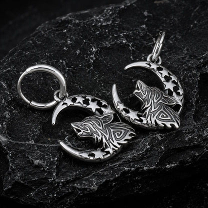 Viking silver wolf and moon hoop earrings with knotwork and star cutouts on dark rock.