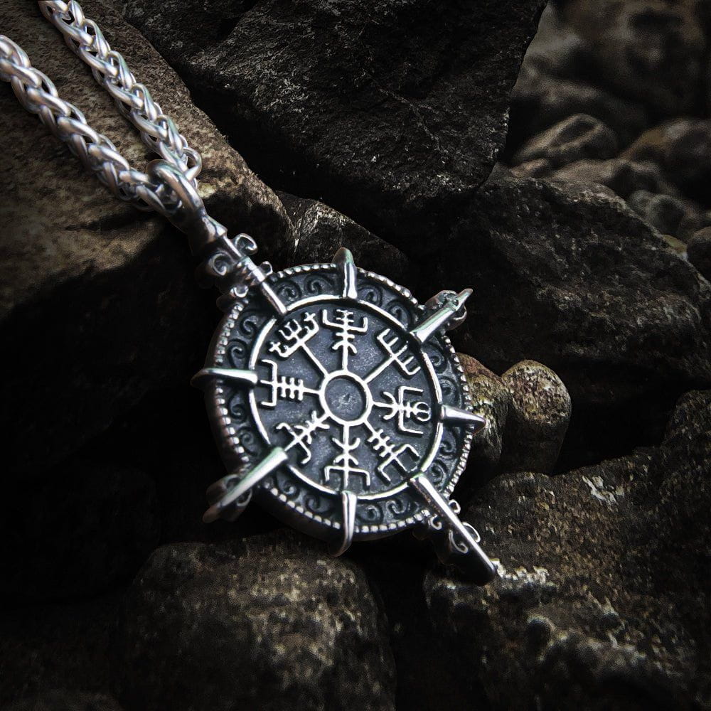 Silver Viking Vegvisir compass talisman necklace on dark rocks.