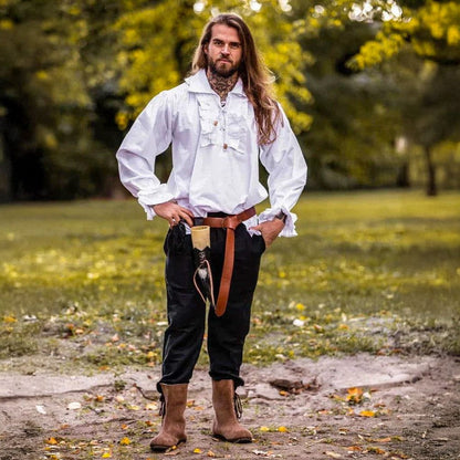 Viking-style white cotton long-sleeve shirt with ruffled neckline & wrists, worn by a man in a park.