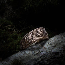 Handmade sterling silver Viking wolf ornament ring with intricate Norse design on a tree branch.