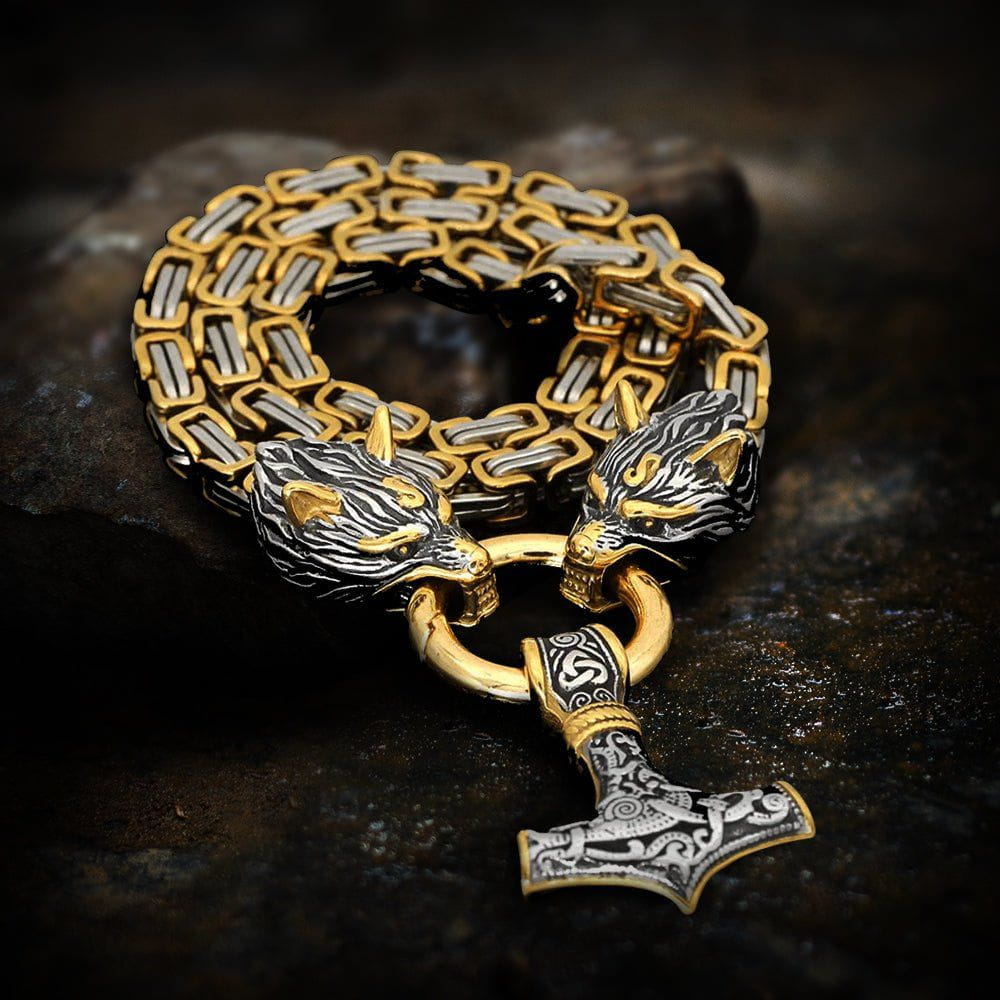 Viking gold and steel necklace with two wolf heads holding a Thor's Hammer Mjolnir pendant.