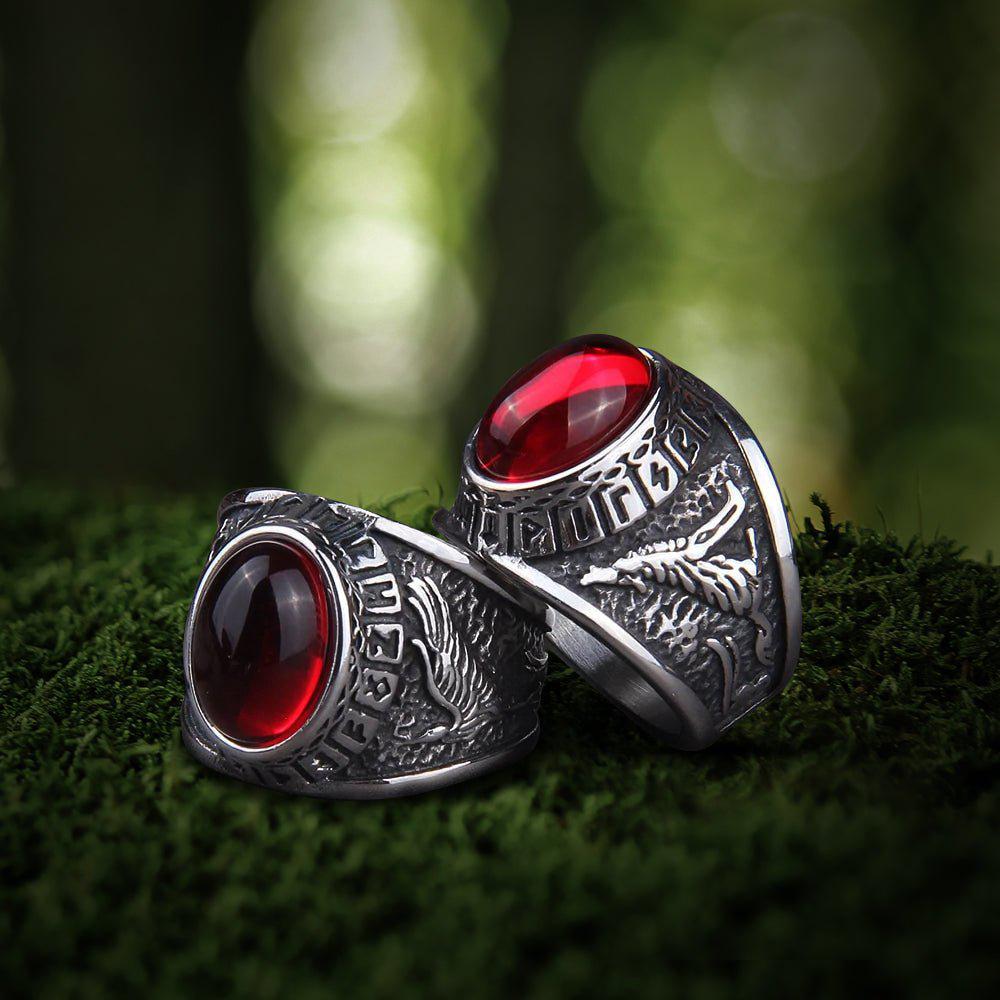 Viking silver signet rings with large red oval gemstones, intricate raven and Futhark carvings.