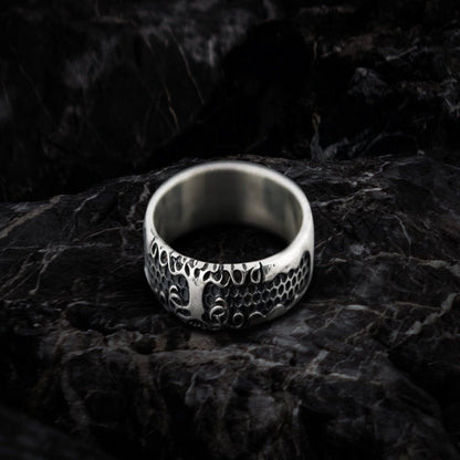 Sterling silver Viking Yggdrasil symbol ring with intricate tree and root design on dark stone.