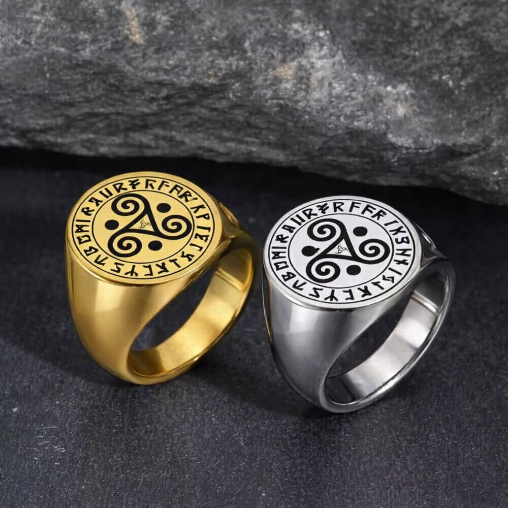Stainless steel Celtic triskele signet rings in gold plated and polished silver featuring triple spiral symbol surrounded by Viking Elder Futhark rune circle. Norse Celtic fusion jewelry for men