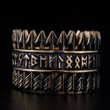 Handcrafted Viking bronze ring featuring three bands – top row of Tyr arrow symbols, center band with complete Elder Futhark runic alphabet, bottom band with diagonal chevron feather pattern – oxidized black finish with raised bronze details