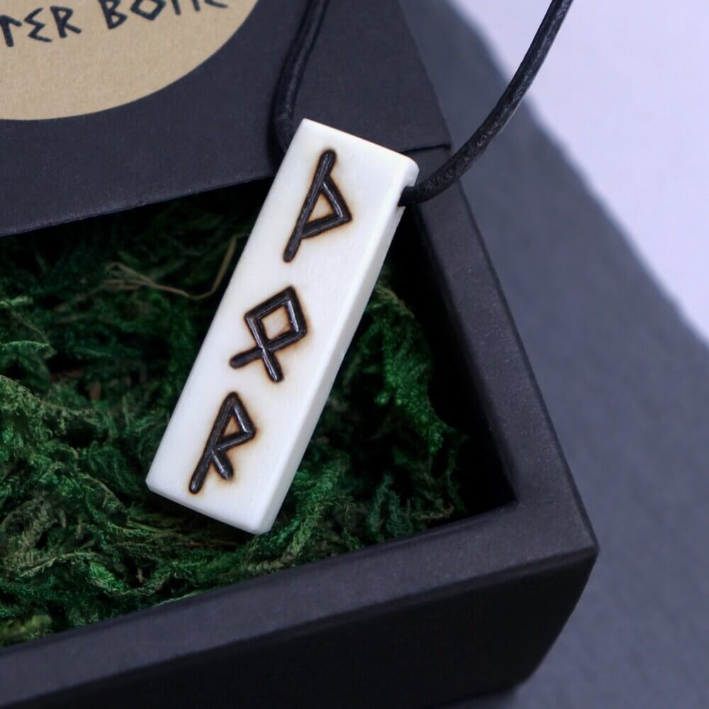 Rune Carved Viking Necklace – Deer Bone Pendant with dark runes, displayed in a black gift box with green moss filler.