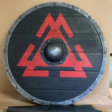 Black wooden Viking round shield with a red Valknut symbol, iron boss, and studded metal rim.