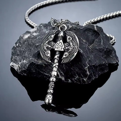 Viking Battle Axe Pendant Necklace with Odin's Ravens & Valknut on braided silver chain displayed on dark stone