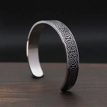 Viking Celtic Knotwork Cuff Bracelet with Endless Knot Design in silver on wooden surface