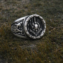 Viking Shield Ring with Tyr Rune in silver, featuring engraved shield face and intricate Nordic details on mossy ground