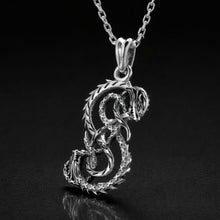 Viking silver Midgard Serpent necklace, intricate coiled dragon pendant on a delicate chain.