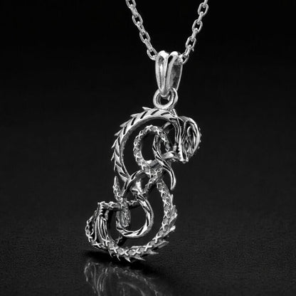 Viking silver Midgard Serpent necklace, intricate coiled dragon pendant on a delicate chain.