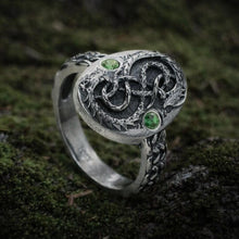 Viking silver serpent ring with intricate knotwork, two green stones, and textured band.