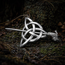 Viking Triquetra Hair Clip with intricate silver knotwork and dragon-head pin, set against mossy forest ground.