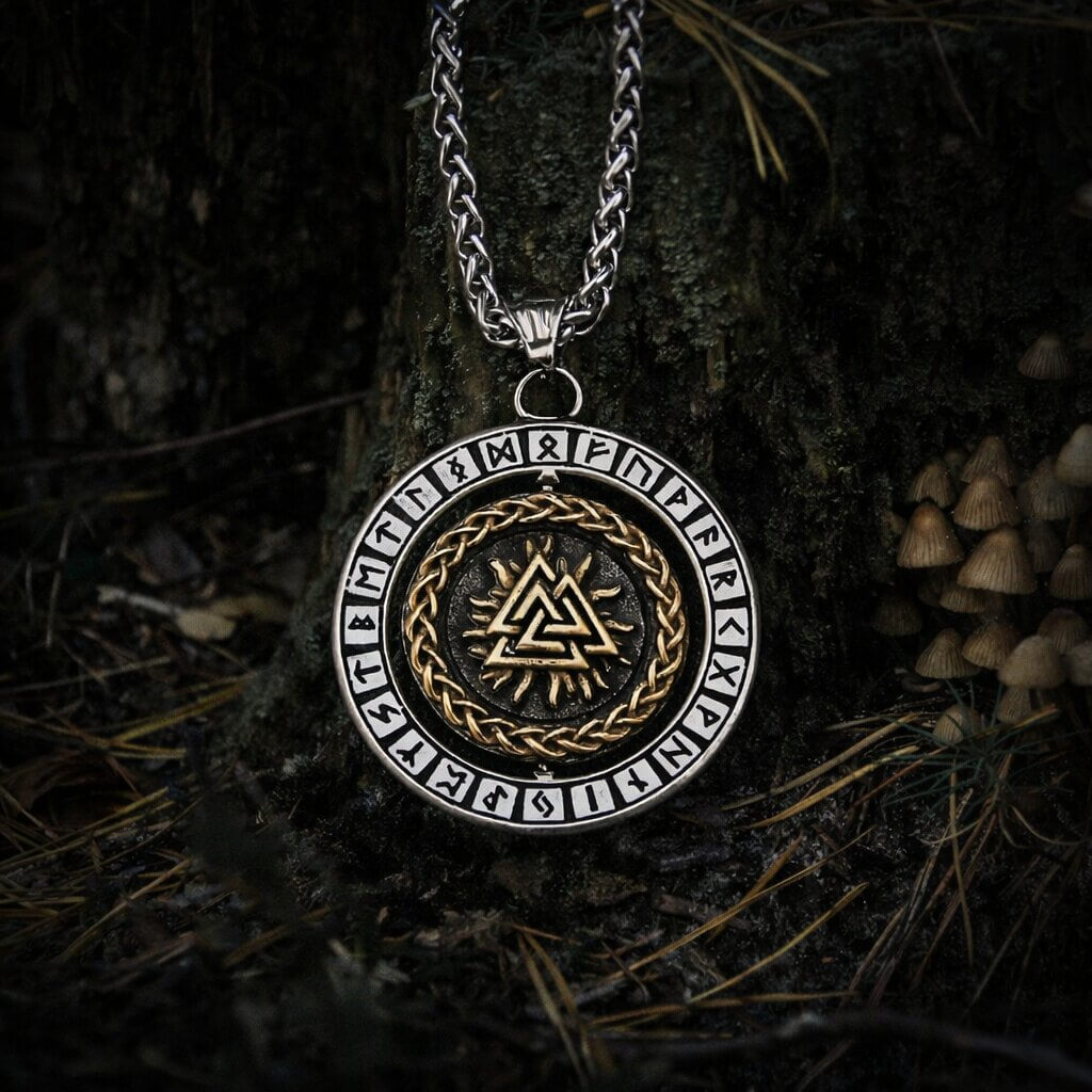Viking Valknut rune pendant necklace with gold Valknut symbol at center, surrounded by a braided gold ring and Elder Futhark runes on the silver outer rim, hanging from a silver wheat chain.