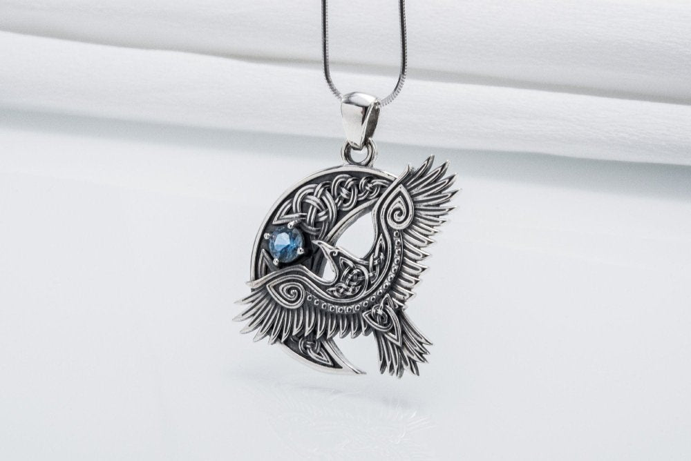 Viking 925 silver raven pendant with intricate Celtic knotwork and a blue gemstone.
